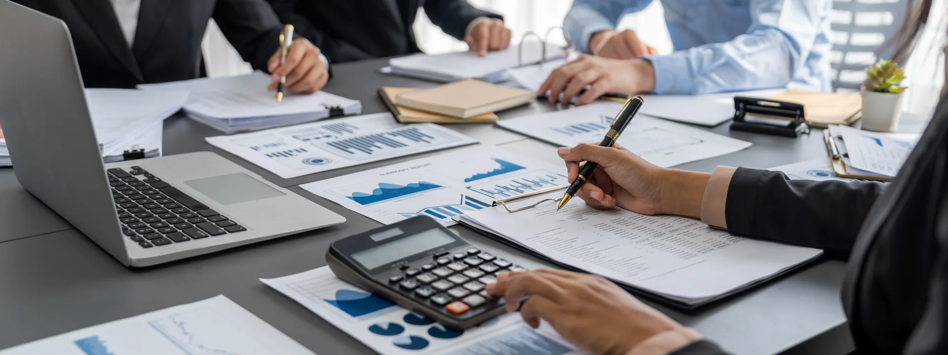 Une équipe échange autour de documents financiers et d’un ordinateur.